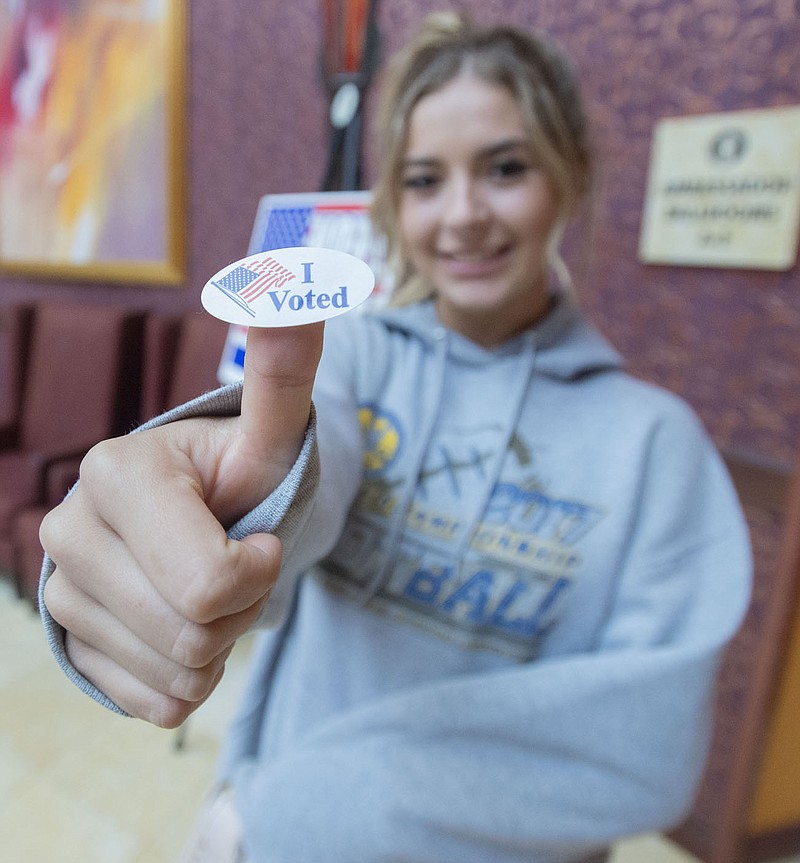 Grace Wixson of Rogers seals shows off her sticker Tuesday Nov. 2, 2021 after voting for the first time at the Rogers Convention Center. Citizens in Benton County voted on school board positions and a school tax. Visit nwaonline.com/210001103Daily/ (NWA Democrat-Gazette/J.T. Wampler)