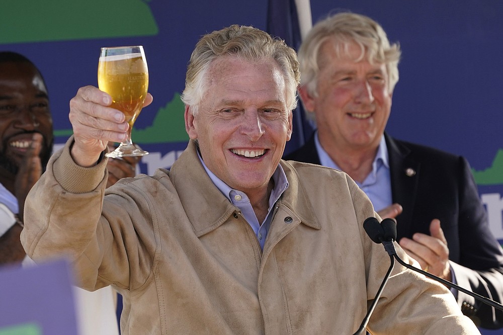 Democratic gubernatorial candidate former Gov. Terry McAuliffe, raises a glass of hard cider as he speaks to supporters during a rally in Richmond, Va., Monday, Nov. 1, 2021. McAuliffe will face Republican Glenn Youngkin in the November election. (AP Photo/Steve Helber)