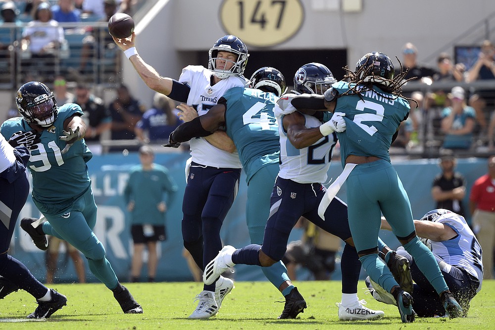 Tennessee Titans quarterback Ryan Tannehill, center, is hit by Jacksonville Jaguars outside linebacker Josh Allen (41) as he releases the ball during the first half of an NFL football game, Sunday, Oct. 10, 2021, in Jacksonville, Fla. (AP Photo/Phelan M. Ebenhack)
