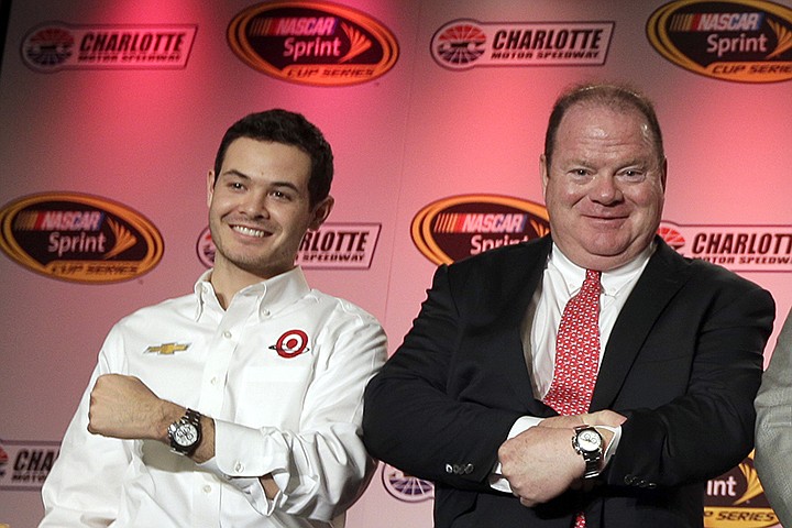 FILE - NASCAR driver Kyle Larson, left, and team owner Chip Ganassi show their Rolex watches for winning the Rolex 24 auto race during the NASCAR Charlotte Motor Speedway media tour in Charlotte, N.C., Thursday, Jan. 29, 2015. Chip Ganassi will &#x201c;absolutely, 100%&#x201d; be rooting for Kyle Larson to win the NASCAR championship in Sunday's, Nov. 7, 2021, finale. What an ironic ending that would be, though, for Larson to win his first championship on Ganassi's final day in NASCAR. Ganassi plucked Larson out of sprint car racing, developed him over nearly eight seasons and then, in Larson's free agency year, was forced to fire him in early 2020 over Larson's use of a racial slur. (AP Photo/Chuck Burton, File)