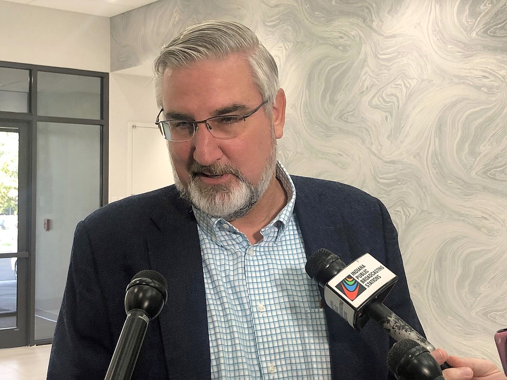 FILE - Indiana Gov. Eric Holcomb speaks with reporters during the Indiana Technology and Innovation Association conference in Fishers, Ind., on Friday, Oct. 8, 2021. President Joe Biden’s plan to require vaccinations at all private employers of 100 workers or more has already hit a wall of opposition from Republican governors, state lawmakers and attorneys general. (AP Photo/Tom Davies, File)