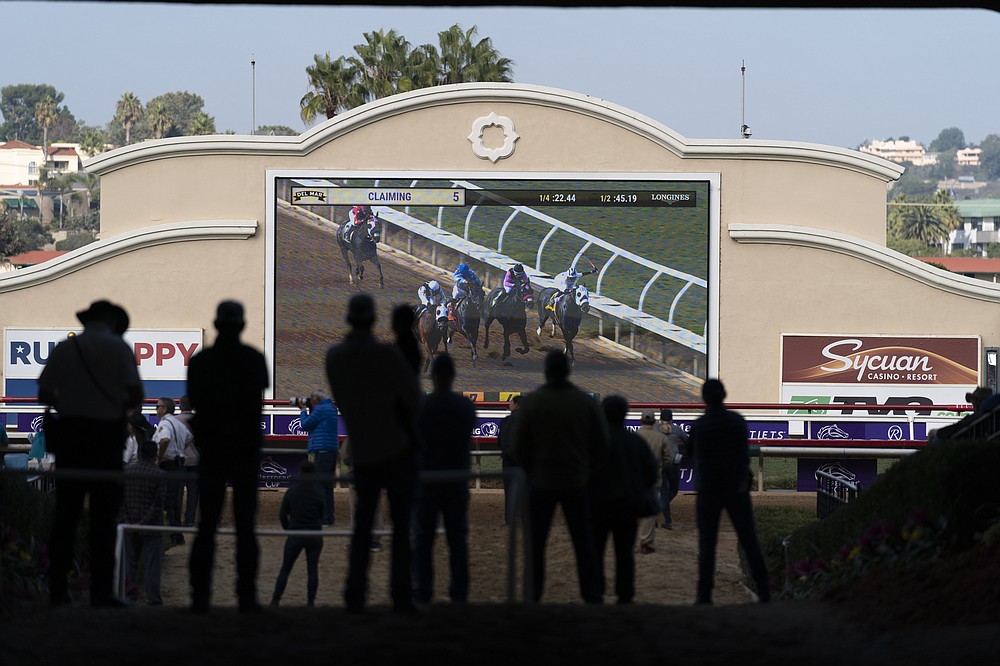People watch a horse race at Del Mar Thorughbred Club race Wednesday, Nov. 3, 2021, in Del Mar, Calif. The Breeders' Cup will be held at Del Mar on Friday and Saturday. (AP Photo/Jae C. Hong)