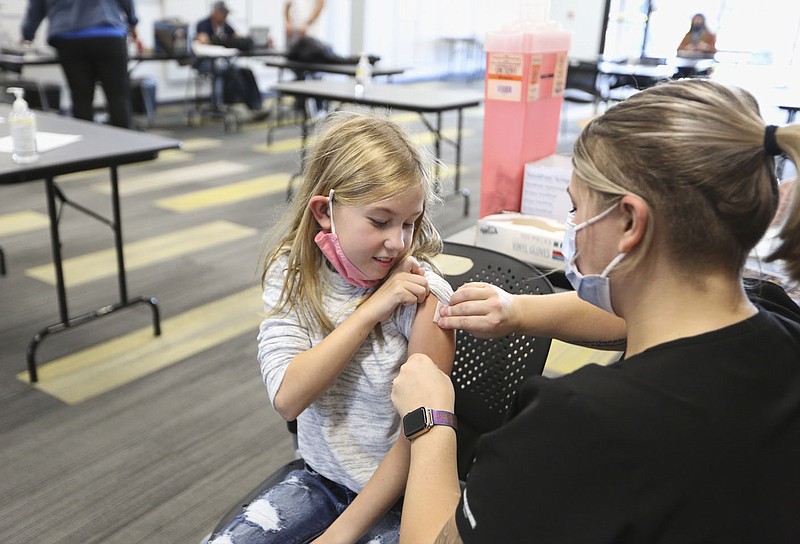 Nurse Stevie Cotton (right) administers a covid-19 vaccine to Hadley Dorminy, 10, Friday at J.B. Hunt in Lowell. Covid vaccines are becoming available for children age 5 through 11. Check out nwaonline.com/211107Daily/ for today's photo gallery. 
(NWA Democrat-Gazette/Charlie Kaijo)