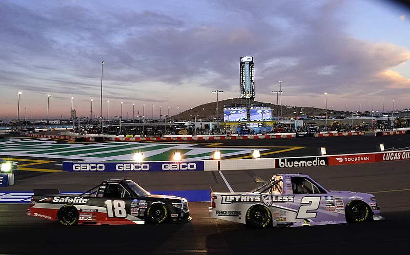 Kris Wright (2) leads Chandler Smith (18) early in the NASCAR Truck Series auto race at Phoenix Raceway on Friday, Nov. 5, 2021, in Avondale, Ariz. (AP Photo/Darryl Webb)