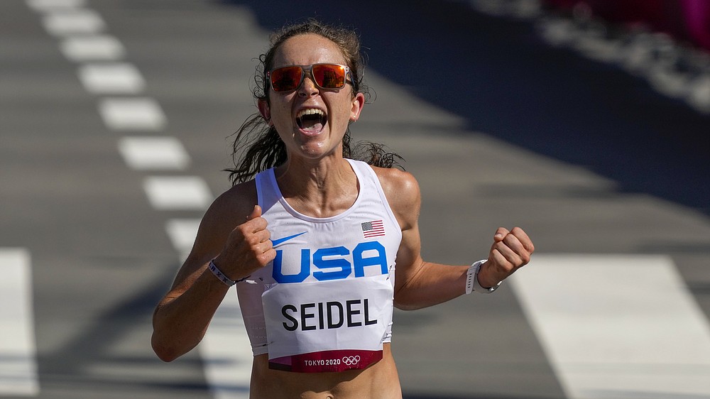 FILE - Molly Seidel, of the United States, celebrates as she crosses the finish line to win the bronze medal in the women's marathon at the 2020 Summer Olympics, Saturday, Aug. 7, 2021, in Sapporo, Japan. Several Olympic medalists will compete in the 50th edition of the New York Marathon on Sunday, Nov. 7, 2021. The most anticipated by fans locally will be Molly Seidel. (AP Photo/Shuji Kajiyama, File)