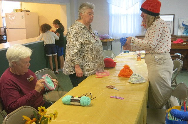 Westside Eagle Observer/SUSAN HOLLAND
Rosetta Selby (seated) works on knitting a hat while Denise Estes receives instruction from Dr. Nancy Jones at the Mad Hatters tea party Sunday afternoon, Nov. 7, at the First Christian Church in Gravette. Several ladies attended to finish knitting hats for Arkansas Childrens Hospital. Others just dropped off knitted or crocheted hats. They enjoyed tea and cookies, sandwiches, cheese and crackers while showing love for children in the area.