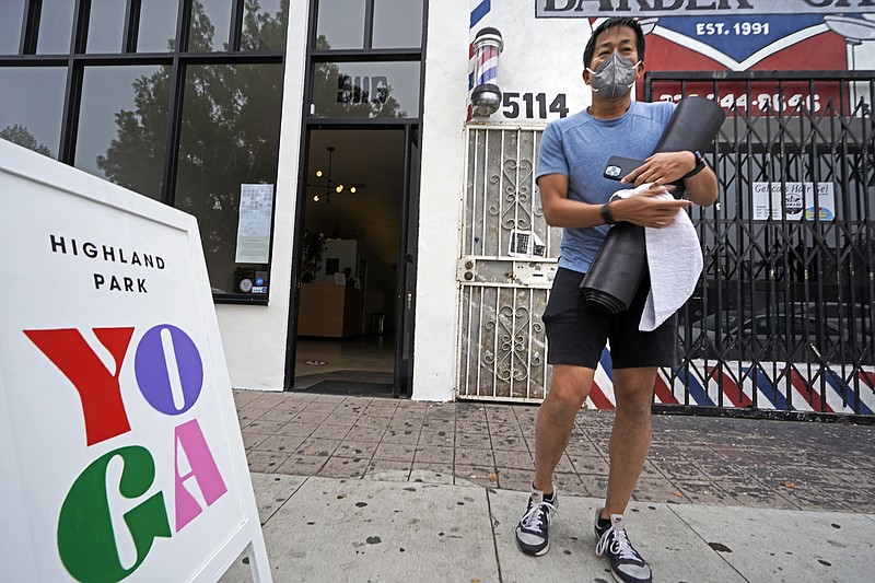 Yoga student Tony Lai wears a N-95 face mask as he leaves his class at the Highland Park Yoga studio in Los Angeles, Saturday, Nov. 6, 2021. A vaccine mandate that is among the strictest in the country takes effect Monday, Nov. 8, in Los Angeles, requiring proof of shots for everyone entering a wide variety of businesses from restaurants to shopping malls and theaters to nail and hair salons. (AP Photo/Damian Dovarganes)