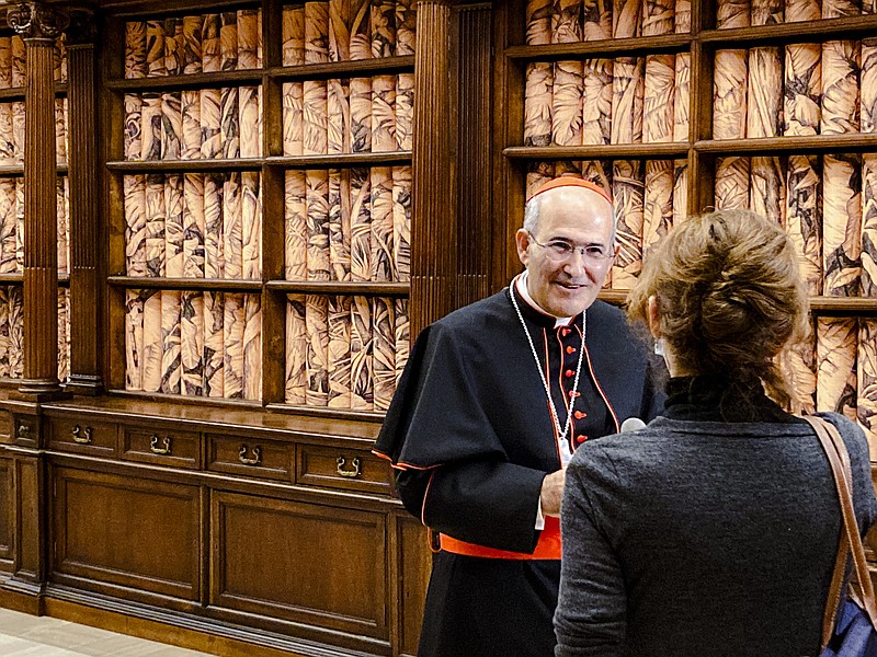 The Vatican Apostolic Librarian, Cardinal Jos&#xe9; Tolentino de Mendon&#xe7;a, left, speaks to a journalist, Monday, Nov. 8, 202, during the presentation to the media of the exhibition &quot;Tutti&quot; (All) inside the Apostolic Library. The exhibition runs through Feb. 22, 2022 and takes its inspiration from Pope Francis' 2020 encyclical &quot;Brothers All&quot; which combines his appeals for environmental sustainability, greater human fraternity and a more just socio-economic order in the post-COVID world. (AP Photo/Nicole Winfield)