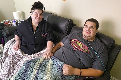 In this Nov. 2, 2021, photo provided by Methodist Jennie Edmundson Hospital, Jonathan Johnson, right, and his wife Mariah, are shown at the couple's home in Council Bluffs, Iowa. As a recovering COVID-19 patient Johnson married his then fiancee, Mariah, on Oct. 14, 2021, in the Critical Care Unit at Methodist Jennie Edmundson Hospital in Council Bluffs, Iowa. (Methodist Health System via AP)