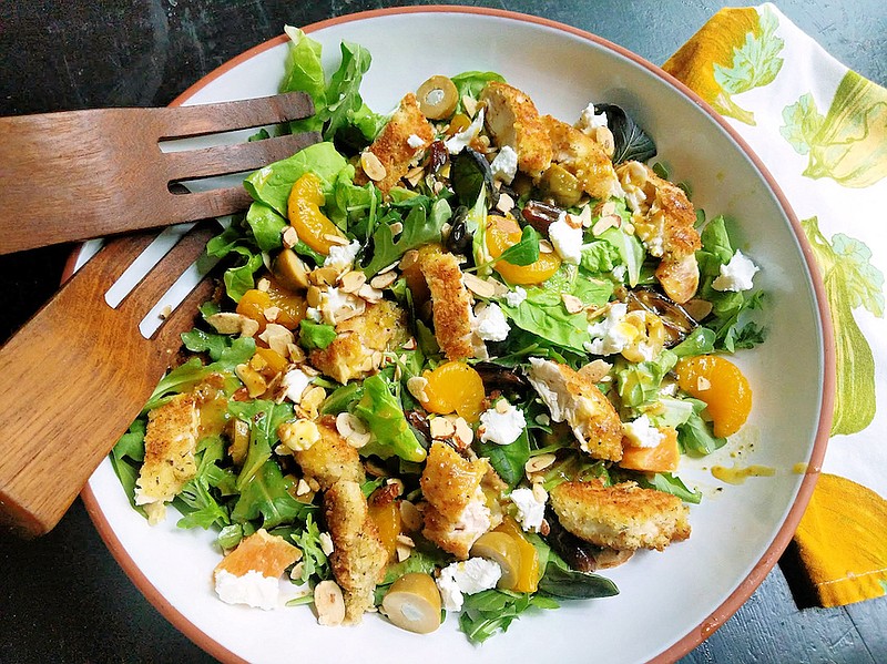 This warm arugula salad delivers a satisfying mix of pan-fried chicken tenders, fresh orange, olives and goat cheese in a warm citrus dressing, with a toasted almond garnish for crunch. (TNS/Pittsburgh Post-Gazette/Gretchen McKay)