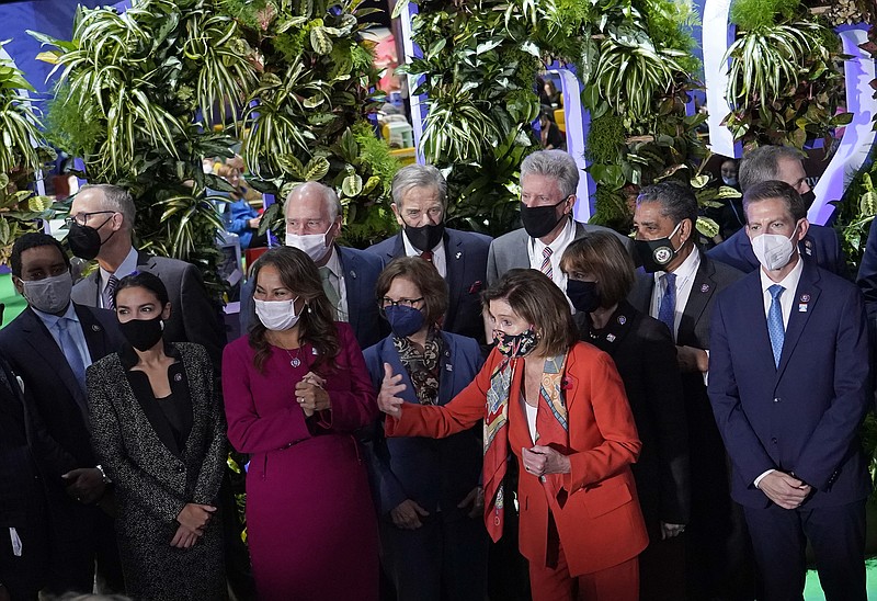 Nancy Pelosi, Speaker of the United States House of Representatives, front, and U.S. Rep. Alexandria Ocasio-Cortez, second left, and other U.S. politicians prepare for a group photo after arriving at the venue of the COP26 U.N. Climate Summit in Glasgow, Scotland, Tuesday, Nov. 9, 2021. The U.N. climate summit in Glasgow has entered its second week as leaders from around the world, are gathering in Scotland's biggest city, to lay out their vision for addressing the common challenge of global warming. (AP Photo/Alberto Pezzali)