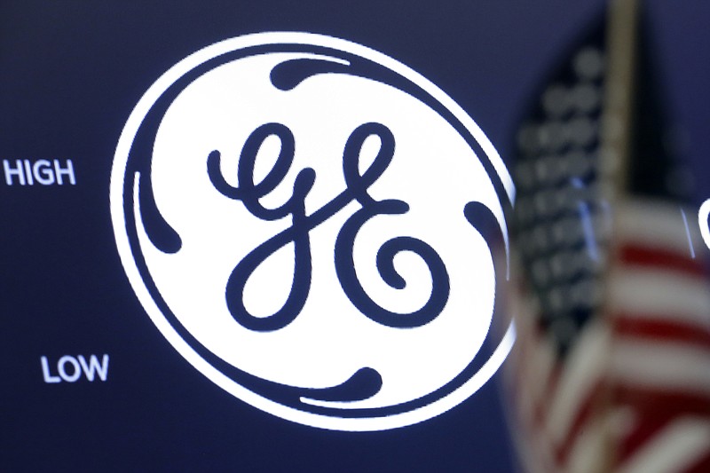 FILE - The General Electric logo appears above a trading post on the floor of the New York Stock Exchange, June 26, 2018. General Electric is splitting itself into three public companies that concentrate on aviation, healthcare and energy. The company said Tuesday, Nov. 9, 2021, that it plans a spinoff of its healthcare business in early 2023 and of its energy segment in early 2024. (AP Photo/Richard Drew, File)