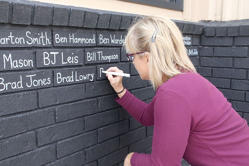 LYNN KUTTER ENTERPRISE-LEADER
Ellen Kriz with Savage Sports is writing the names of customers who purchased products in August during a campaign called "Brick by Brick" for the new company Keto Savage in Lincoln. Kriz said the bricks are a way for the company to thank its followers who have helped the company grow. She is writing names on more than 1,200 bricks, she said.