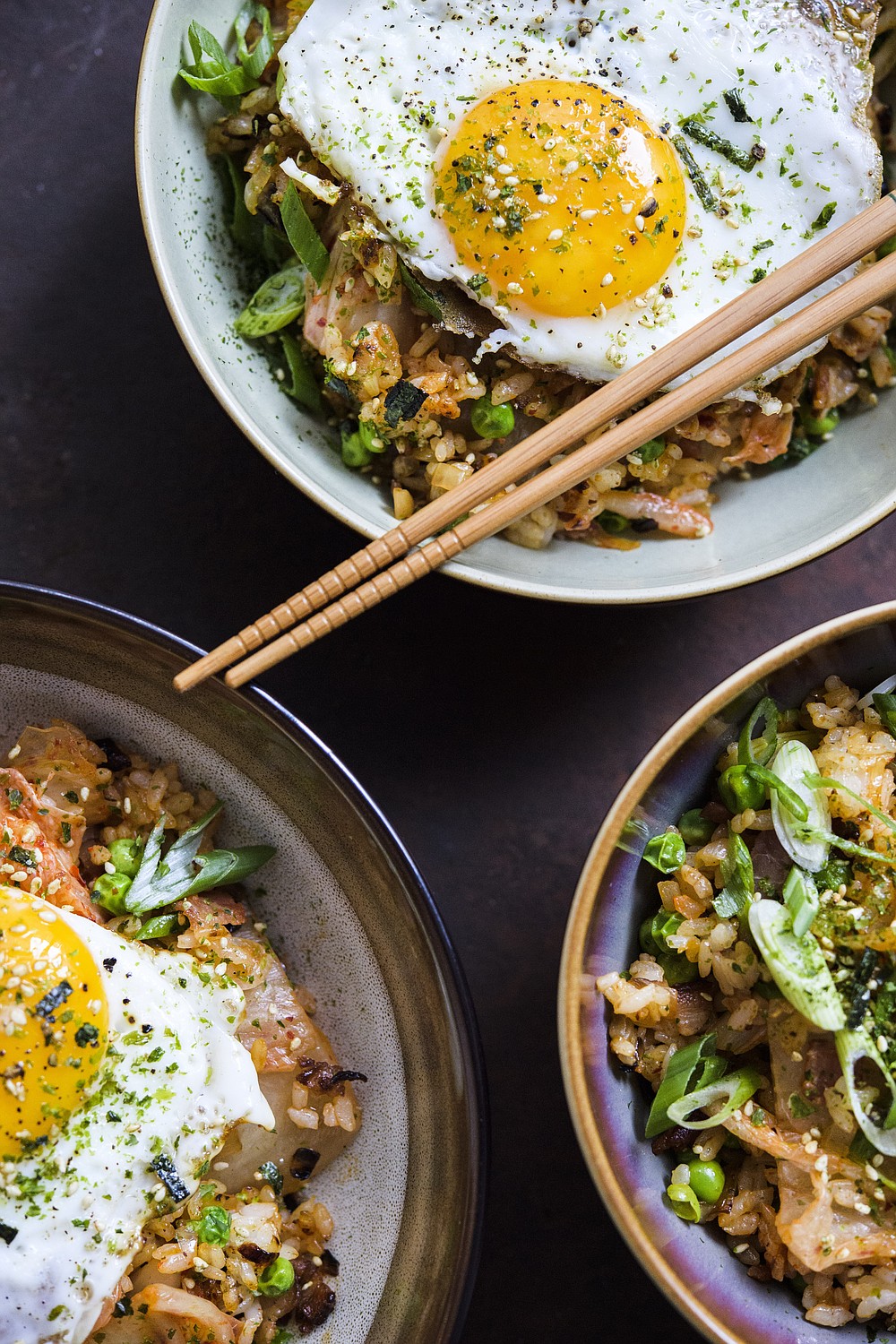 This image released by Milk Street shows a recipe for Kimchi and bacon fried rice, topped with a fried egg and sprinkled with furikake. (Milk Street via AP)