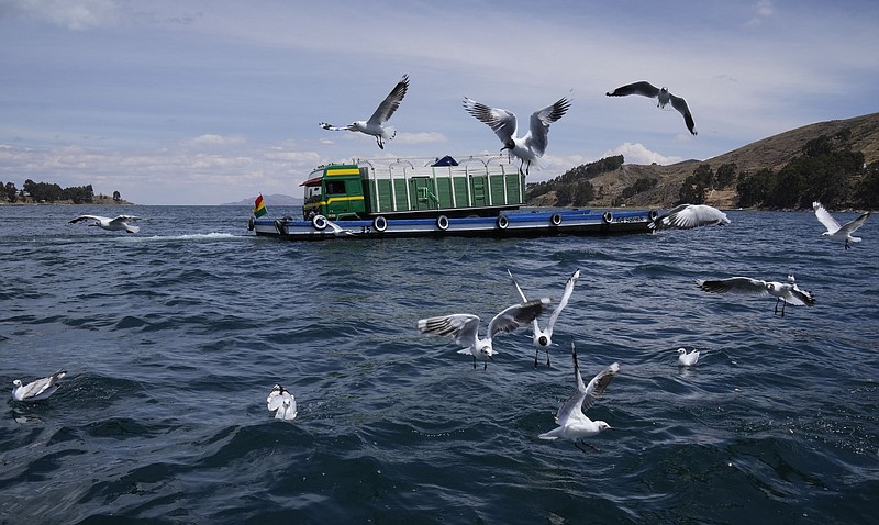 A boat carries a truck on Lake Titicaca Lake in Tiquina, Bolivia, Wednesday, Nov. 10, 2021. The freshwater Lake Titicaca, the highest in the world, is located on Bolivia's border with Peru. (AP Photo/Juan Karita)