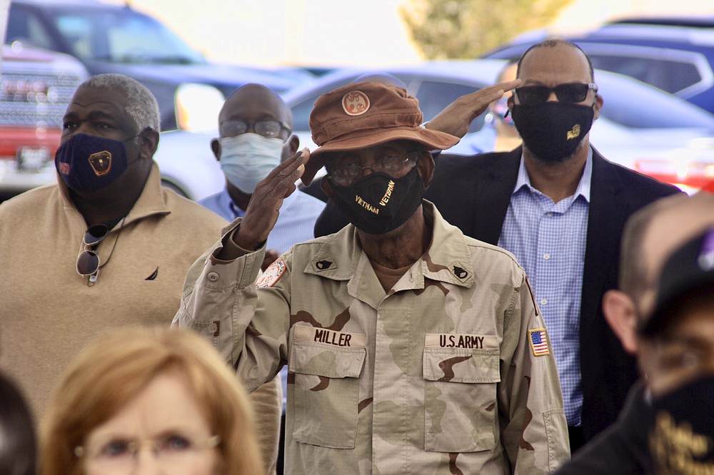 Veterans stand proudly and salute during the opening ceremony of the Sgt. Elga Lee Roberts Jefferson County Veterans Service Office. (Pine Bluff Commercial/Eplunus Colvin)