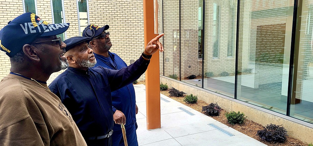 Veterans Perry Davis, Joseph James O’Neal Jr. and James Jones spend time in the memorial garden courtyard at the new Sgt. Elga Lee Roberts Jefferson County Veterans Service Office. (Pine Bluff Commercial/Eplunus Colvin)