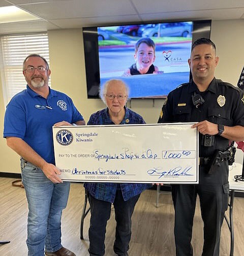 The Springdale Kiwanis club is offering support to Springdale Police's Shop with a Cop program. Pictured are President Larry Peckham and Dolores Stamps as they present Officer Jarred Pena a check for $1,000. Kiwanis is dedicated to the children of the community.

(Courtesy photo)