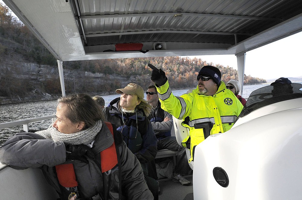 Jay Schneider, assistant superintendent at Hobbs State Park-Conservation Area, drives the park's pontoon boat during an eagle watch cruise in 2013. Cruises set sail on Saturdays and Sundays. Some weekday trips are held near the holidays.
(NWA Democrat-Gazette file photo/Flip Putthoff)