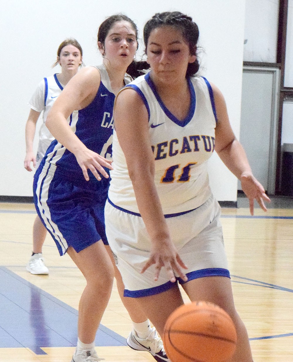 Westside Eagle Observer/MIKE ECKELS
Jackie Mendoza (11) dibbles away from the top of the key in an attempt to evade a Lady Griffin defender during the Decatur-Ozark Catholic girls basketball contest in Bentonville Nov.9. Mendoza managed to pass to the corner but the Lady Bulldog shooter missed the basket and the ball went to the Lady Griffins.