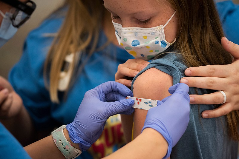 Marin Ackerman, 10, of Upper Arlington, Ohio, gets a bandage after receiving a dose of the Pfizer-BioNTech COVID-19 vaccine during a clinic for kids ages 5 to 11. (Joshua A. Bickel/Columbus Dispatch/TNS)