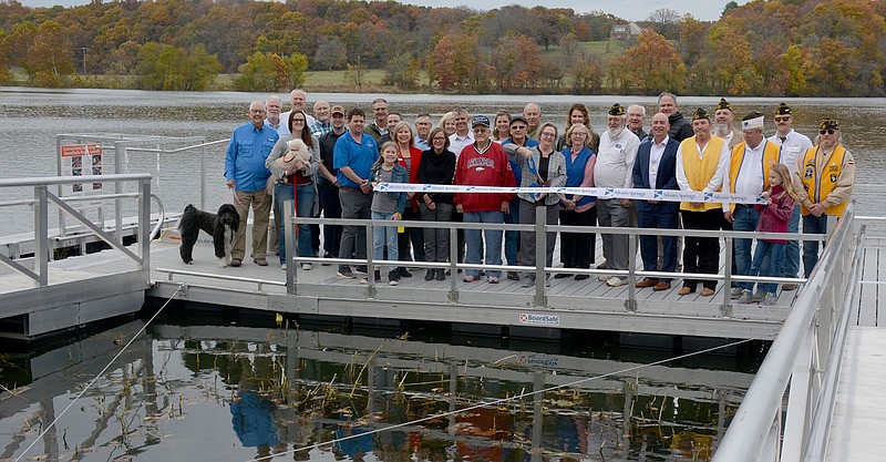 Graham Thomas/Siloam Sunday
Donors, members of the Siloam Springs City Board and other invited guests watch as Siloam Springs Mayor Judy Nation cuts the ribbon during a ribbon cutting ceremony on Wednesday at the ADA Accessible Fishing Pier and Kayak Launch at City Lake Park.