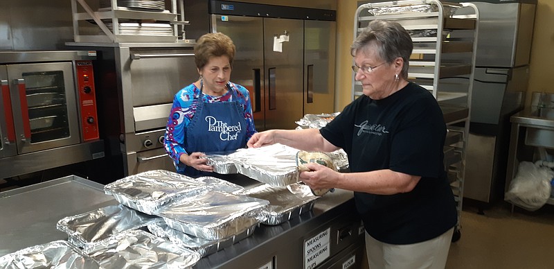 Marylyn Hall and Sue James, both congregation members at Hardy Memorial Methodist Church, continue preparations for that evening’s turkey dinner, a decades-long church tradition. (Staff photo by Junius Stone)