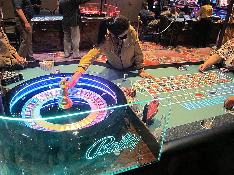 This June 23, 2021 photo shows a dealer conducting a game of roulette at Bally's casino in Atlantic City, N.J. Figures released Nov. 9, 2021 from the American Gaming Association show the nation's commercial casinos won nearly $14 billion in the third quarter of this year, marking the best three-month period in history for the industry, which is poised to have its best full year ever in 2021.
