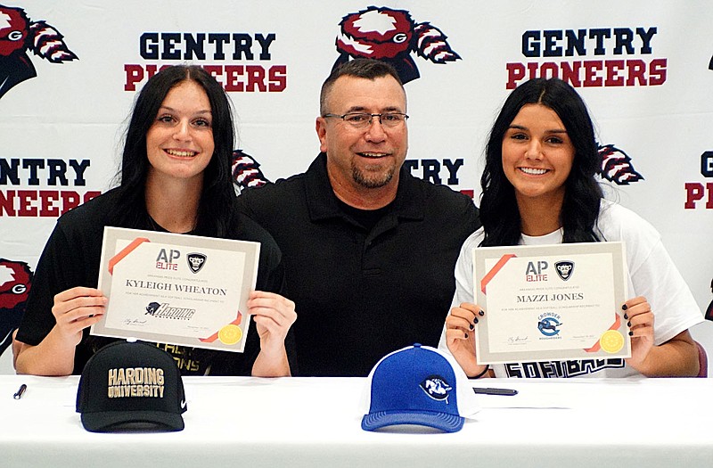 Westside Eagle Observer/RANDY MOLL
Gentry seniors Kyleigh Wheaton and Mazzi Jones, with Coach Clay Stewart, show certificates from Harding University and Crowder College at a signing event at Gentry High School on Nov. 10. Wheaton, who has pitched for the Lady Pioneers all four years, signed her letter of intent to attend Harding University and play softball there next year. Jones, an infielder for the Lady Pioneers and also a four-year veteran, signed to attend and play for Crowder College. Stewart coached the girls for many years on travel teams and then assisted as a volunteer coach at the high school.