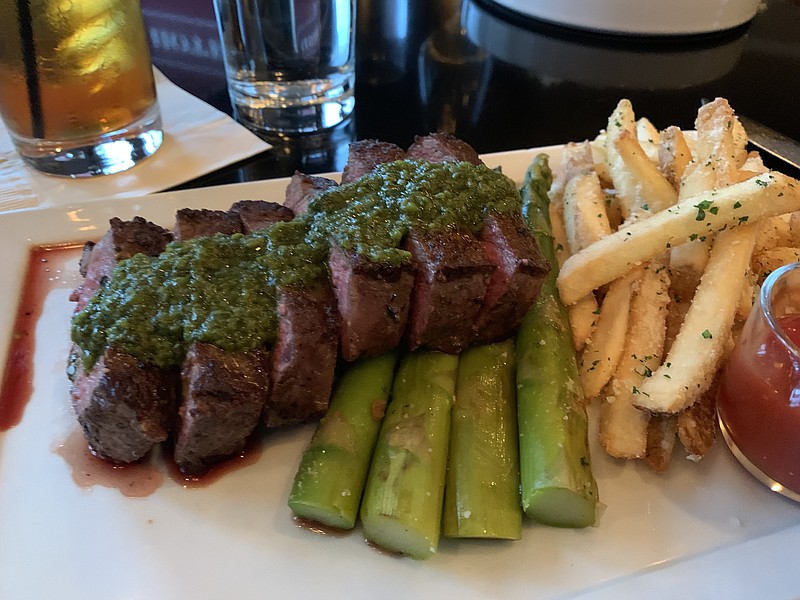 Steak Frites, a 12-ounce prime New York Strip, pre-sliced and topped with chimichurri, came with parmesan fries and asparagus at Capital Bar & Grill. (Arkansas Democrat-Gazette/Eric E. Harrison)