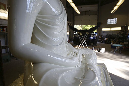 A fiberglass statue of the Buddha is restored at Exoticars, an auto restoration shop specializing in classic vehicles, in McCandless, Pa., on Monday, Oct. 11, 2021. After weeks of repair and repainting, the statue was unveiled at the Pittsburgh Buddhist Center on Oct. 24. (AP Photo/Jessie Wardarski)