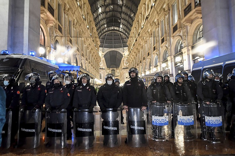 Riot Police patrol the Galleria Vittorio Emanuele II shopping arcade during a protest against the COVID-19 vaccination green pass, in Milan, Italy, Saturday, Nov. 13, 2021. (Claudio Furlan/LaPresse via AP)