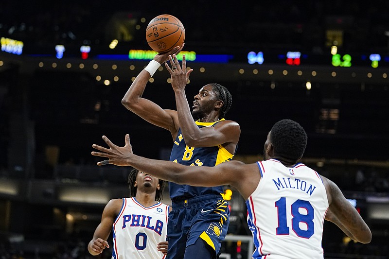 Indiana Pacers forward Justin Holiday (8) shoots over Philadelphia 76ers guard Shake Milton (18) during the second half of an NBA basketball game in Indianapolis, Saturday, Nov. 13, 2021. The Pacers defeated the 76ers 118-113. (AP Photo/Michael Conroy)