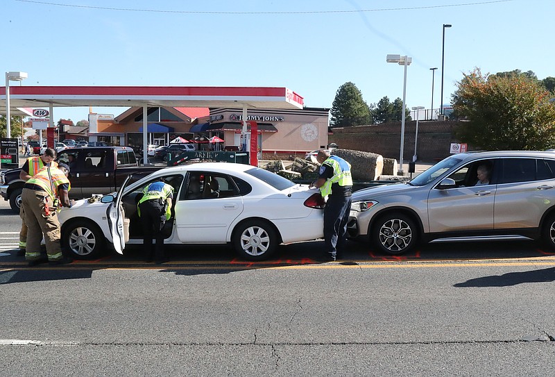 Hot Springs fire and police personnel work the scene of a two-vehicle wreck that occurred shortly before noon Monday near the intersection of Central Avenue and Section Line Road. - Photo by Richard Rasmussen of The Sentinel-Record
