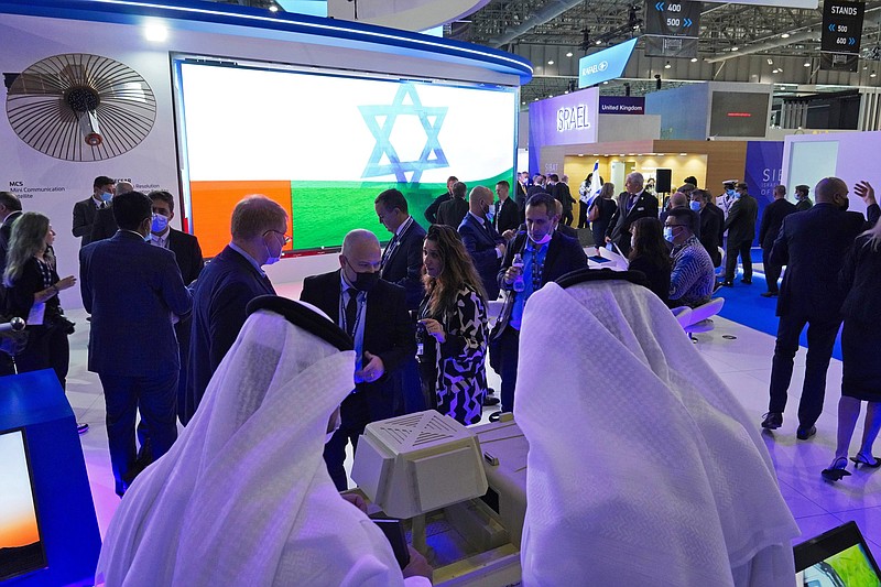 An Emirati and Israeli flag flash across a screen in the Israel Aerospace Industries stand at the Dubai Air Show in Dubai, United Arab Emirates, Monday, Nov. 15, 2021. Israel is taking part in the Dubai Air Show for the first time after the United Arab Emirates recognized the country last year. (AP Photo/Jon Gambrell)