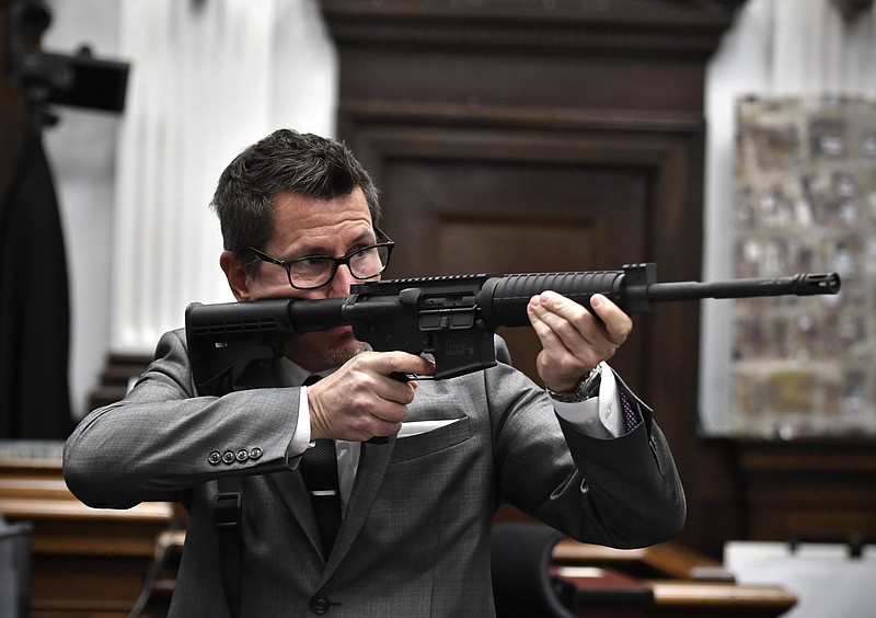 Assistant District Attorney Thomas Binger holds Kyle Rittenhouse's gun as he gives the state's closing argument in Kyle Rittenhouse's trial at the Kenosha County Courthouse in Kenosha, Wis., on Monday, Nov. 15, 2021.  Rittenhouse is accused of killing two people and wounding a third during a protest over police brutality in Kenosha, last year.  (Sean Krajacic/The Kenosha News via AP, Pool)