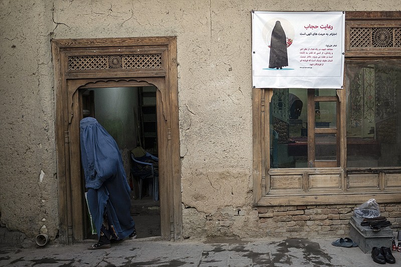 A woman leaves a Shiite shrine in a predominantly Hazara neighborhood in Kabul, Afghanistan, Tuesday, Nov. 9, 2021. A strange, new relationship is developing in Afghanistan following the takeover by the Taliban three months ago. The Taliban, Sunni hard-liners who for decades targeted the Hazaras as heretics, are now their only protection against a more brutal enemy: the Islamic State group. (AP Photo/Bram Janssen)