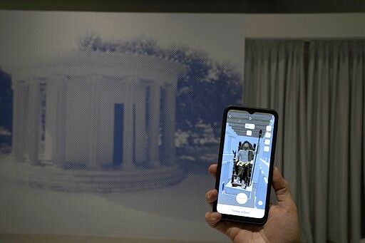 Museum technician Kostas Baskakis uses an app at the Olympic Museum in Athens, Greece, Tuesday, Nov. 9, 2021. The installation is part of a digital restoration project by Microsoft and the Greek Ministry of Culture and Sport at Ancient Olympia, birthplace of the Olympic Games. (AP Photo/Thanassis Stavrakis)