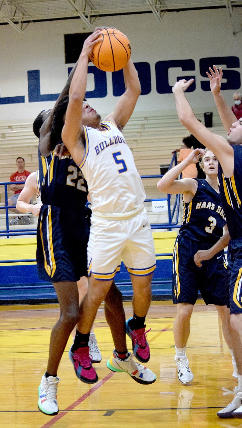 Westside Eagle Observer/MIKE ECKELS
Andres Revolorio (Decatur 5) and Joshua Ofodile (Mastiffs 22) fight for a rebound in the second quarter of the Decatur-Haas Hall-Fayetteville varsity boys basketball contest at Peterson Gym in Decatur Nov. 15. These two teams along with six others from around Northwest Arkansas participated in the Decatur Invitational Basketball Tournament. Decatur defeated Haas Hall 56-35.