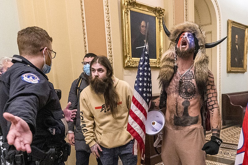 Supporters of President Donald Trump, including Jacob Chansley, right with fur hat, are confronted by U.S. Capitol Police officers outside the Senate chamber inside the Capitol during the capitol riot in Washington, Jan. 6, 2021. Chansley was sentenced on Wednesday, Nov. 17, 2021, to 41 months in prison for his felony conviction for obstructing an official proceeding. Though he wasn't accused of violence, Chansley acknowledged he was among the first 30 rioters in the building, offered thanks while in the Senate for having the chance to get rid of traitors and wrote a threatening note to Vice President Mike Pence. (AP Photo/Manuel Balce Ceneta, File)