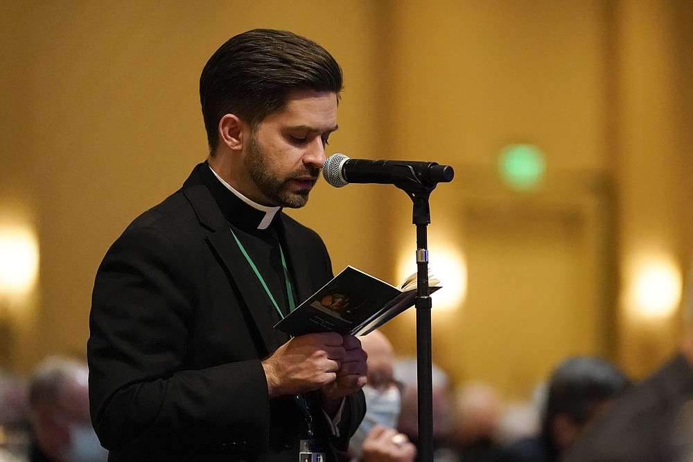 A clergyman leads prayer during the Fall General Assembly meeting of the United States Conference of Catholic Bishops, Wednesday, Nov. 17, 2021, in Baltimore.(AP Photo/Julio Cortez)