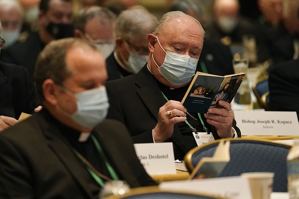 Bishop Glen Provost, right, of the Diocese of Lake Charles, La., and Bishop Manuel Cruz, left, of the Roman Catholic Archdiocese of Newark, N.J., read scripture during a morning prayer at the Fall General Assembly meeting of the United States Conference of Catholic Bishops, Wednesday, Nov. 17, 2021, in Baltimore.(AP Photo/Julio Cortez)