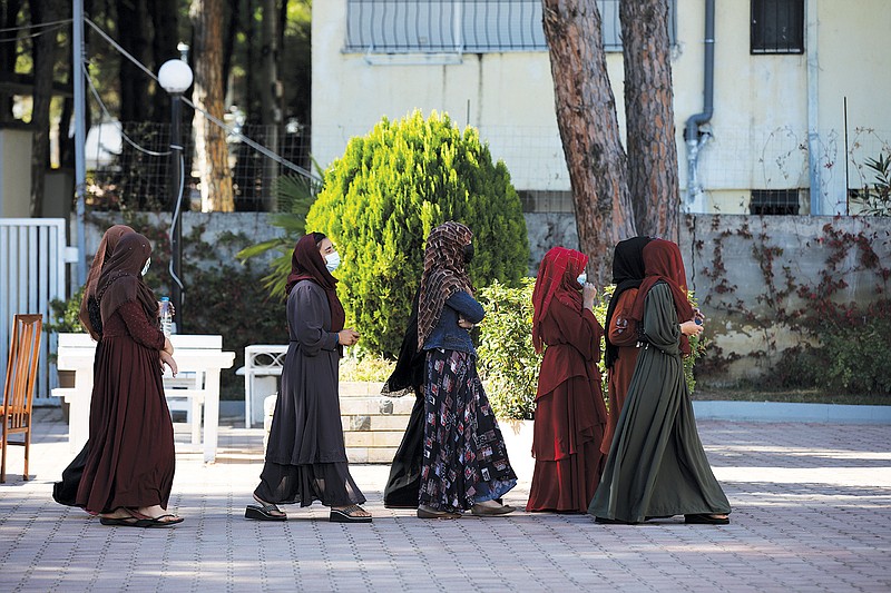 Afghan women with headscarves walk at a coastline tourist resort in Golem, 50 kilometers (30 miles) west of Tirana, Albania, Wednesday, Oct. 27, 2021. A group of Afghans evacuated earlier this month are housed at an Albanian coastline tourist resort enjoying the warm welcome and a normal daily life. The last group of judges, sportsmen, journalists, activists, artists, law enforcement officers, scientists and more arrived earlier in October. They all miss and fear of the fate of their families back home. (AP Photo/Franc Zhurda)