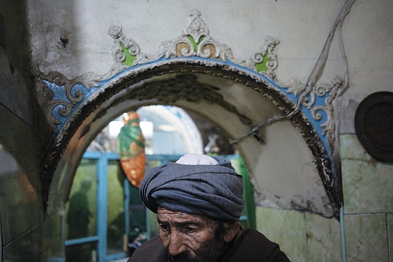 A Hazara man enters a Shiite shrine in Kabul, Afghanistan, Friday, Nov. 5, 2021. A strange, new relationship is developing in Afghanistan following the takeover by the Taliban three months ago. The Taliban, Sunni hard-liners who for decades targeted the Hazaras as heretics, are now their only protection against a more brutal enemy: the Islamic State group. (AP Photo/Bram Janssen)