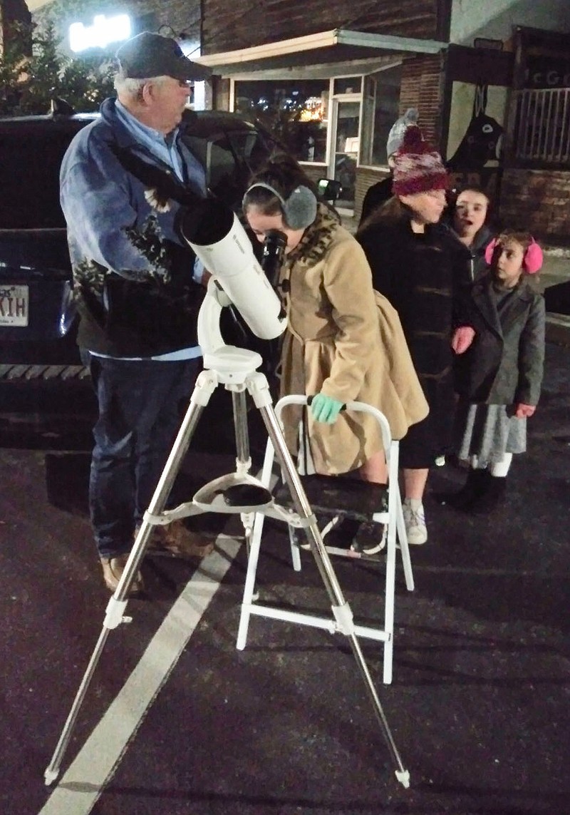 Submitted Photo
Howard Gilmer of Bella Vista looks over the group as his granddaughters line up to look through a telescope during the library's Moon Over Main Street event Saturday evening, Nov. 13. Moon Over Main was truly a family affair as Gilmer brought granddaughters Cloey, Emilia, Sophia, Briella and Olivia. They were among about 70 people who attended the event which was a part of the NASA@MyLibrary space science program.