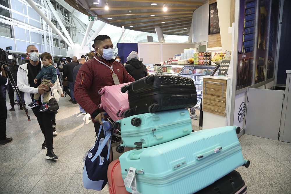 Iraqi migrants arrive to the airport in Irbil, Iraq, Thursday, Nov. 18, 2021.Hundreds of Iraqis have returned home from Belarus after abandoning their hopes of reaching the European Union in a repatriation that follows more than a week of tensions at Poland's eastern border, where thousands of migrants were stuck in a cold and soggy forest. (AP Photo.Hussein Ibrahim)