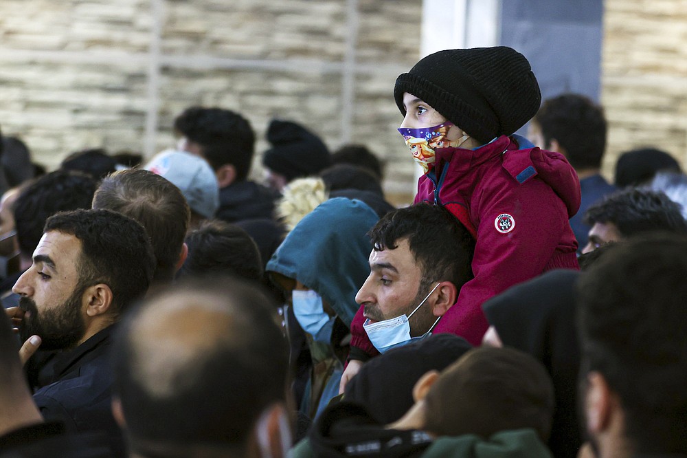Migrants from Iraq lineup to be registered on a special flight to Iraq at the National Airport outside Minsk, Belarus, Thursday, Nov. 18, 2021. A plane carrying migrants back to Iraq is due to leave the Belarusian capital Minsk on Thursday, part of efforts by the Iraqi authorities to help citizens to have been stranded at the border between Belarus and Poland in the hope of getting into the European Union. Spokesman of the Iraqi Foreign Minister Ahmed Al Sahhaf said Thursday that at least 430 people have registered to return to Iraq from Belarus, and the authorities were in process of registering 50 more. (Andrey Pokumeiko/BelTA via AP)