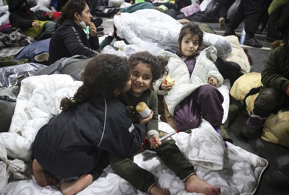 Migrants settle for the night in the logistics center in the checkpoint "Kuznitsa" at the Belarus-Poland border near Grodno, Belarus, on Thursday, Nov. 18, 2021. A plane carrying migrants back to Iraq is due to leave the Belarusian capital Minsk on Thursday, part of efforts by the Iraqi authorities to help citizens to have been stranded at the border between Belarus and Poland in the hope of getting into the European Union. Spokesman of the Iraqi Foreign Minister Ahmed Al Sahhaf said Thursday that at least 430 people have registered to return to Iraq from Belarus, and the authorities were in process of registering 50 more. (Leonid Shcheglov/BelTA via AP)