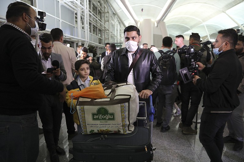 Iraqi migrants arrive to the airport in Irbil Iraq, Thursday, Nov. 18, 2021.Hundreds of Iraqis have returned home from Belarus after abandoning their hopes of reaching the European Union in a repatriation that follows more than a week of tensions at Poland's eastern border, where thousands of migrants were stuck in a cold and soggy forest. (AP Photo.Hussein Ibrahim)