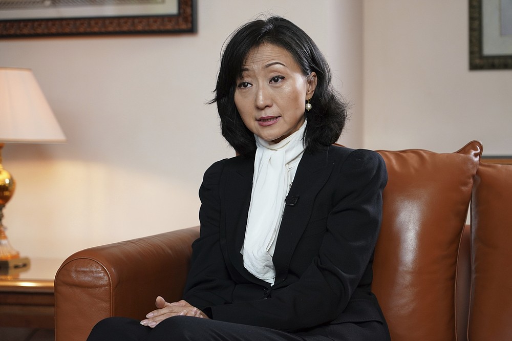 Grace Meng, the wife of former Interpol president Meng Hongwei, answers the Associated Press in Lyon, central France, Tuesday, Nov.16, 2021. In the exclusive interview, Meng chose to show her face for the first time since her husband disappeared in China in 2018, agreeing to be filmed and photographed without the dark lighting and from-the-back camera angles that she had previously insisted on. (AP Photo/Laurent Cipriani)